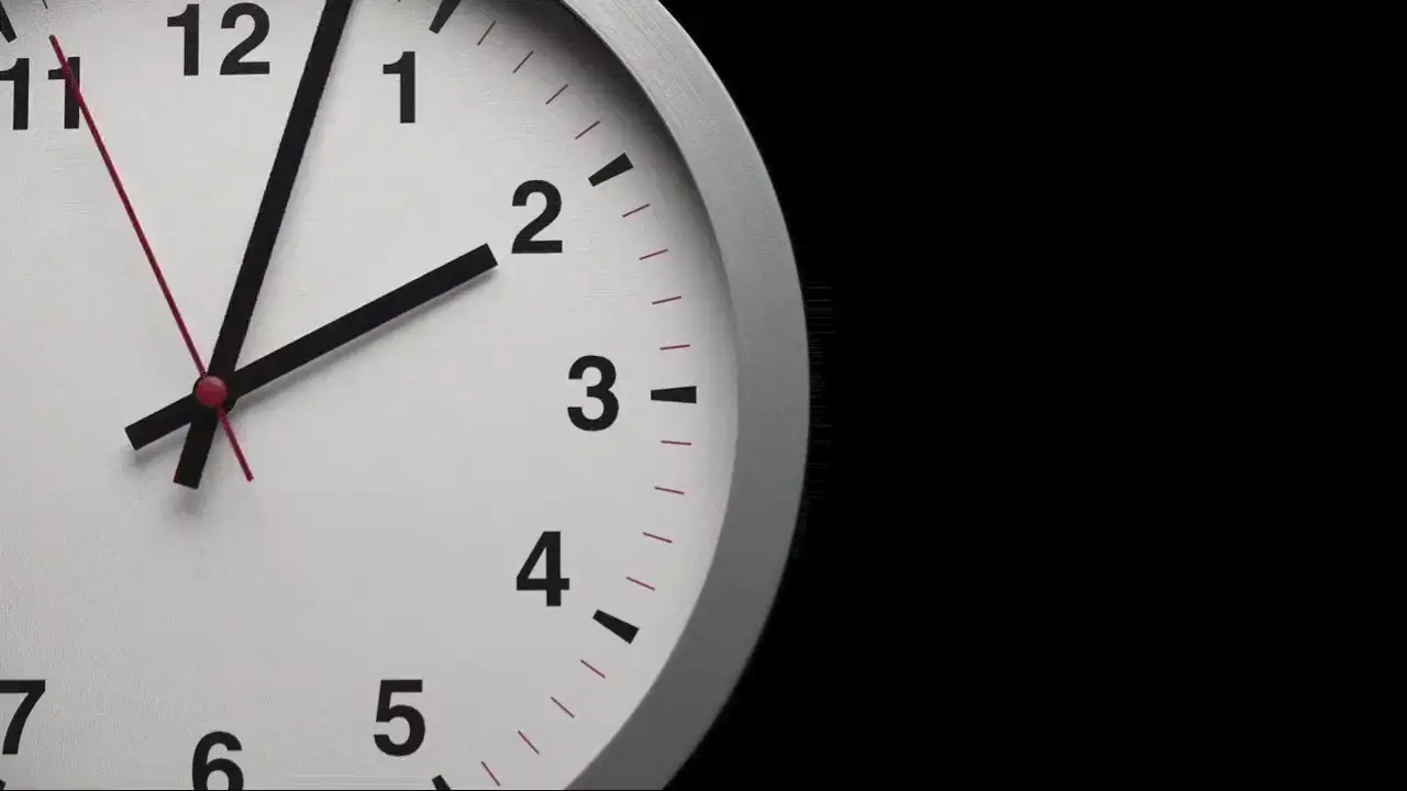Wall clock face with its hands showing a few minutes past three