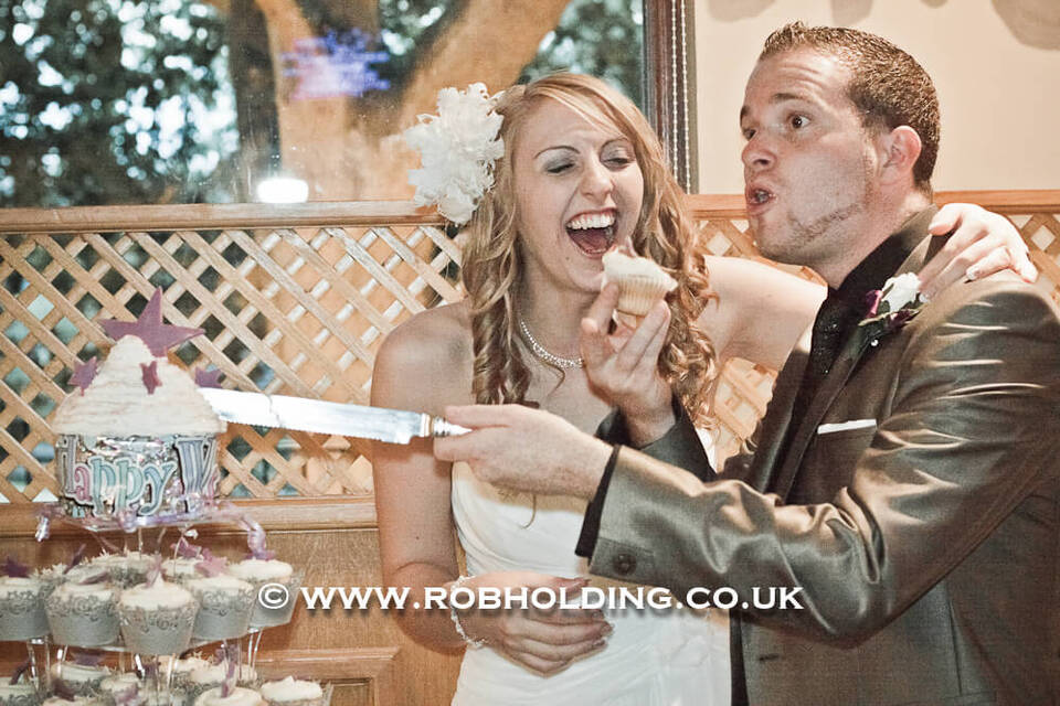 Bride and groom playfully feeding each other cake