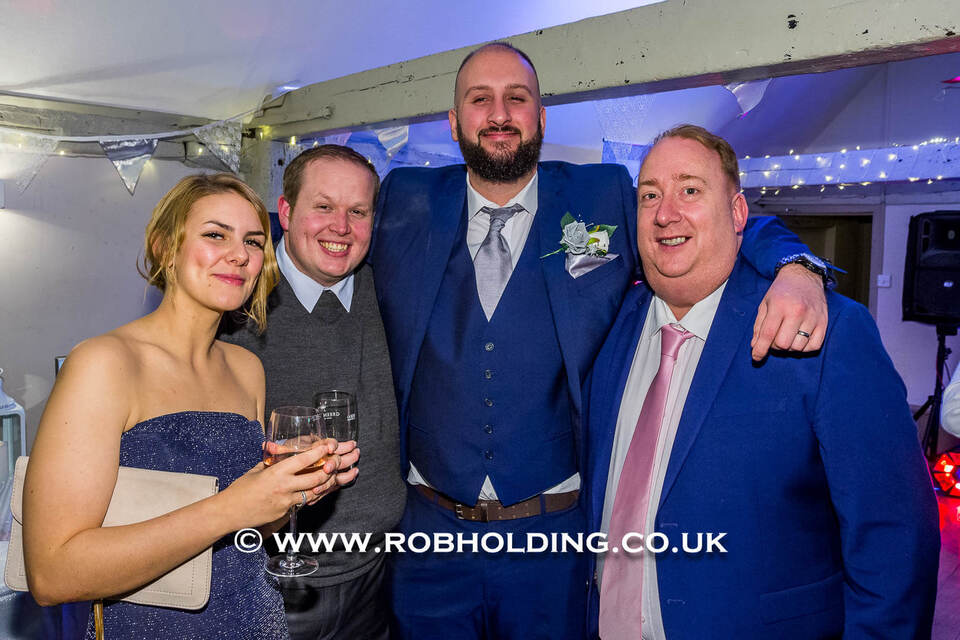 Three men and a woman posing together at the reception