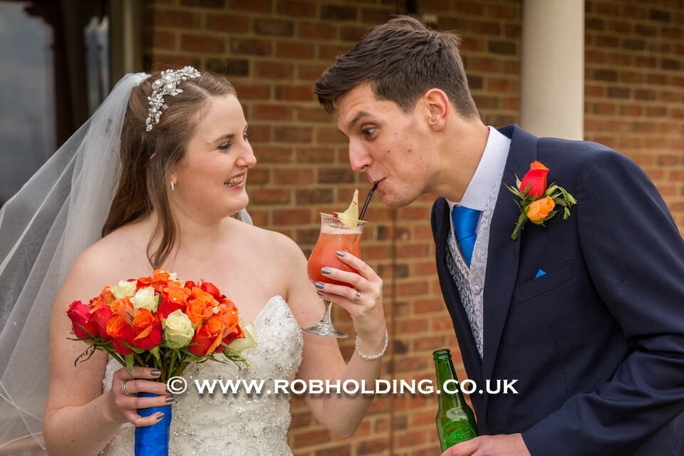 Bride and groom sharing a drink together through straws