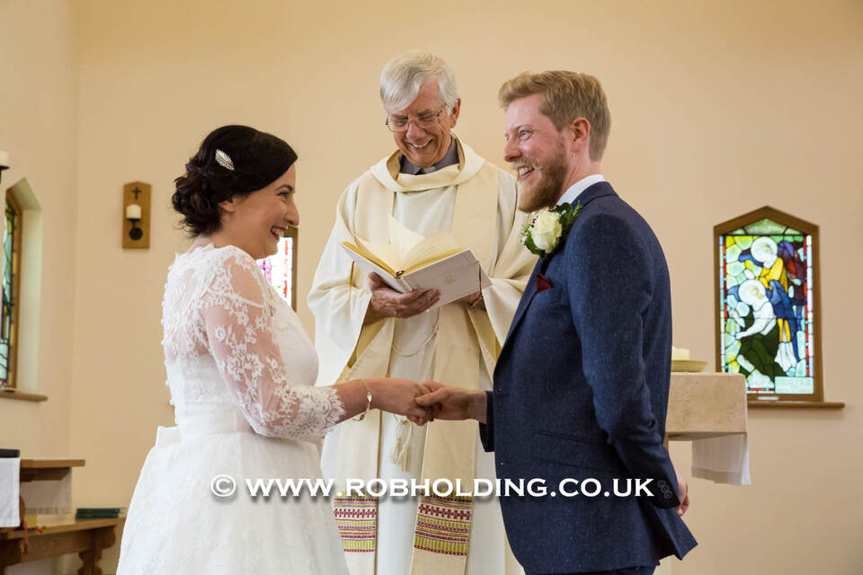 Bride and groom holding hands at the altar
