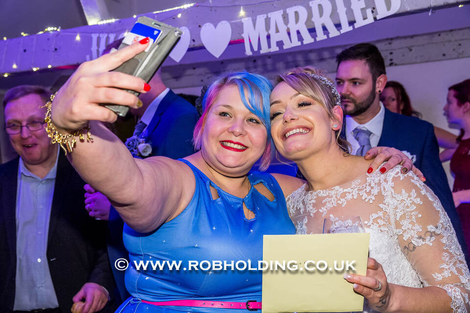 Two wedding guests taking a selfie at the reception