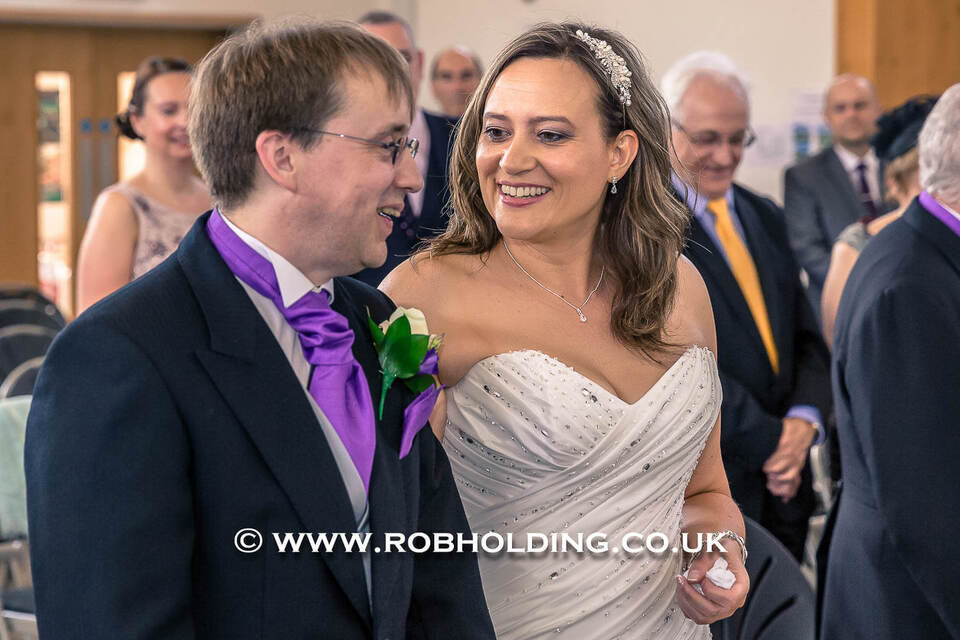 Groom and bride walking arm in arm, smiling