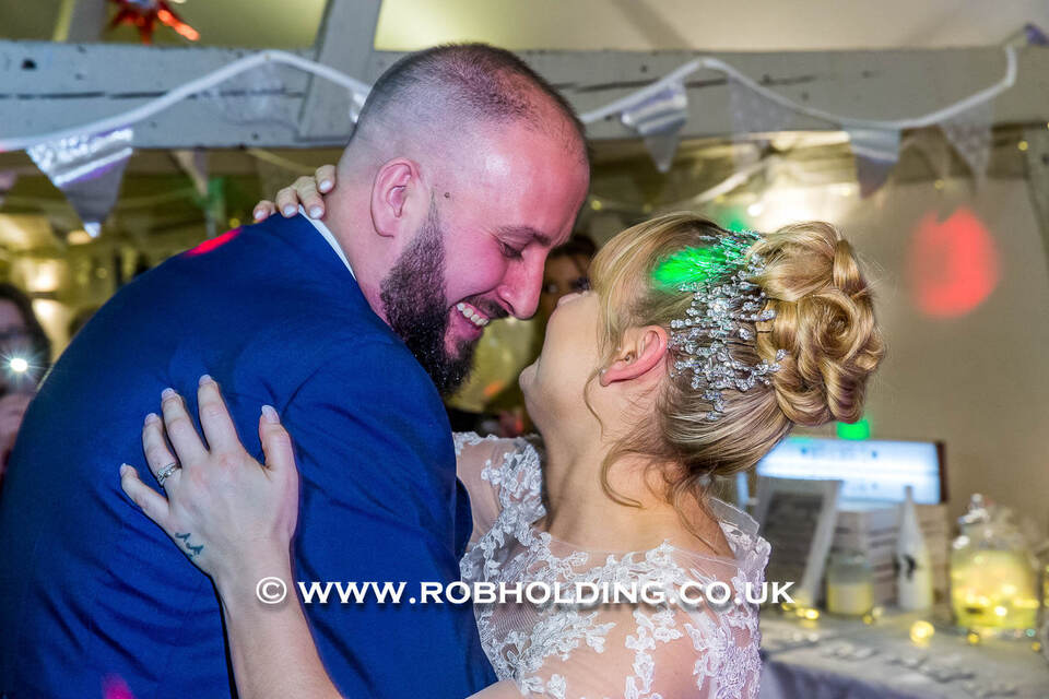 Groom and bride dancing closely at the reception