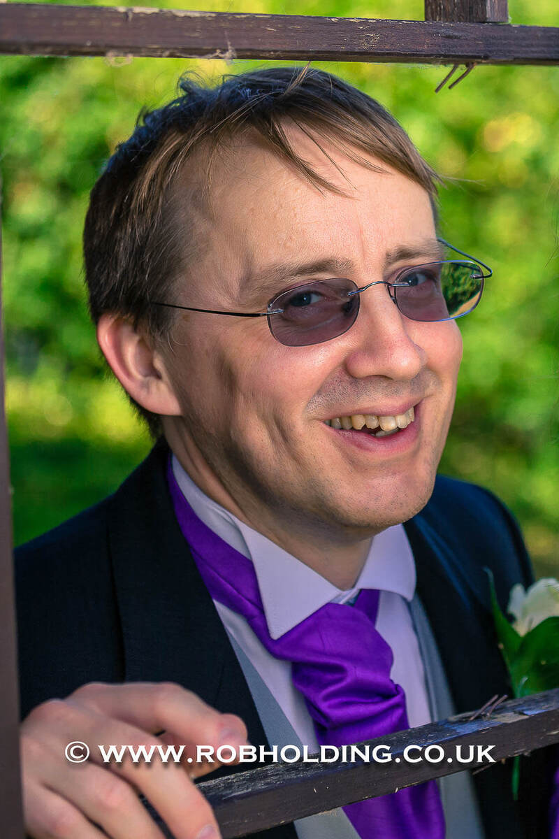 Portrait of a man wearing sunglasses and a purple cravat