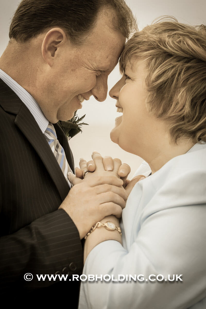 Groom sharing a tender moment with an older woman, foreheads touching