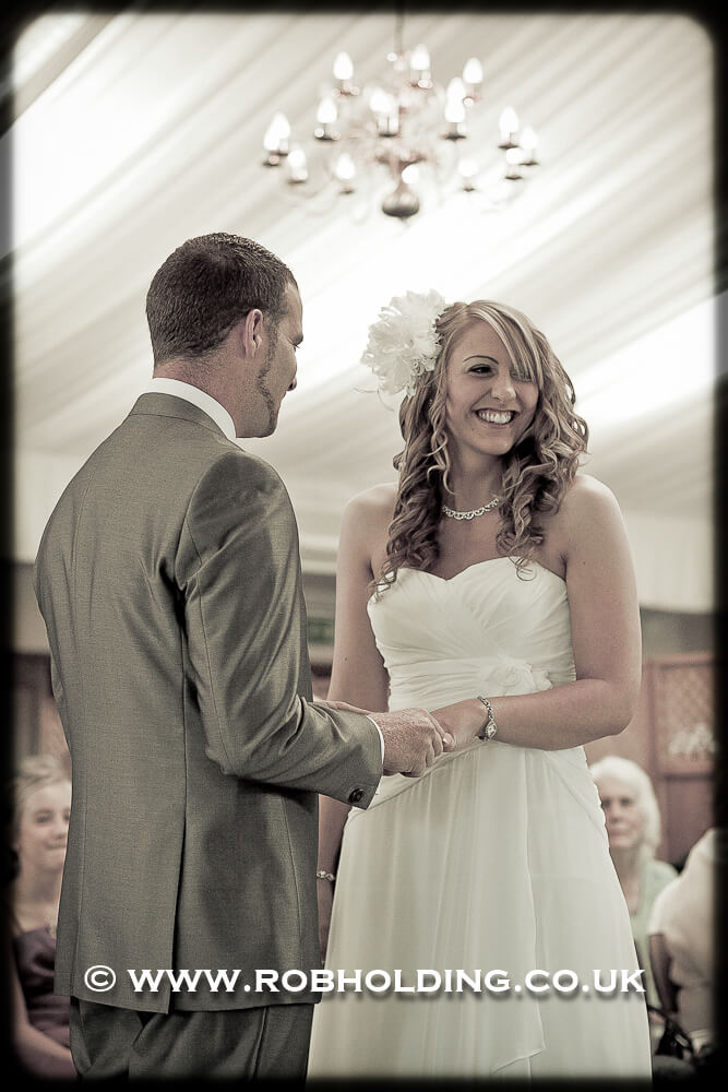 Bride and groom holding hands under a marquee
