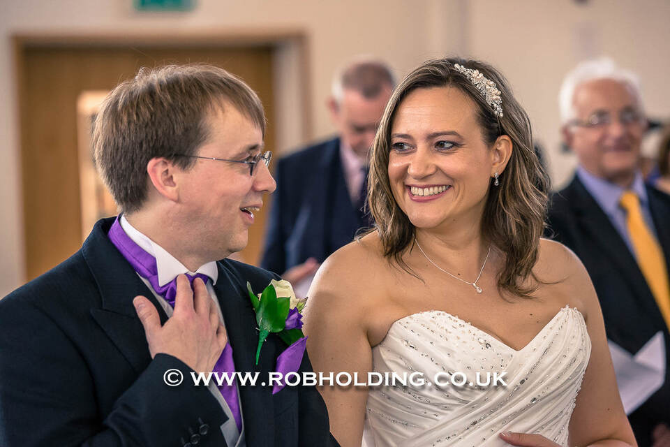Bride and groom smiling closely together indoors