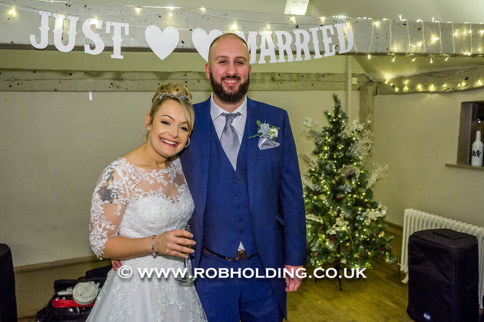 Bride and groom under a "Just Married" sign indoors