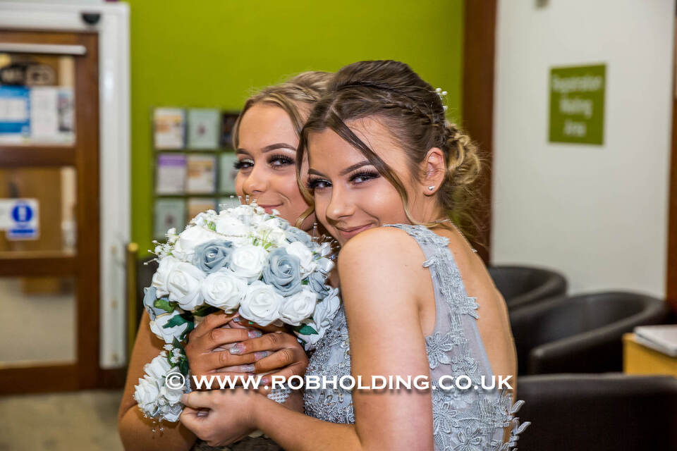 Two bridesmaids embracing warmly indoors