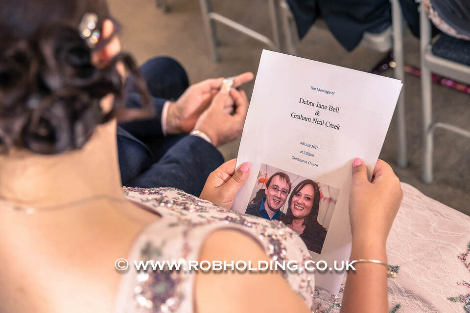 Close-up of an order of service booklet featuring a photo of the couple