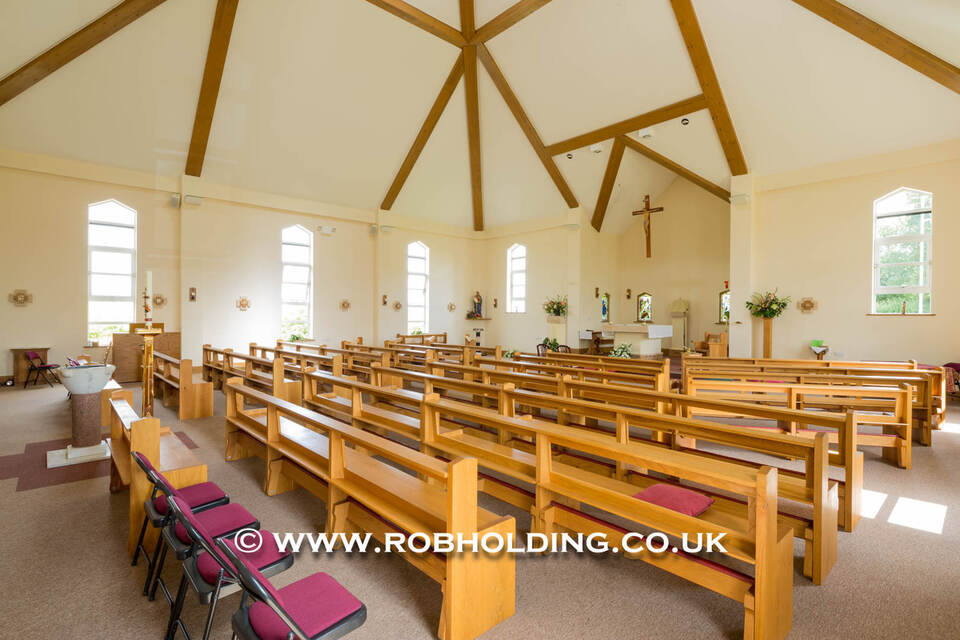Empty church interior with wooden pews and a beamed ceiling