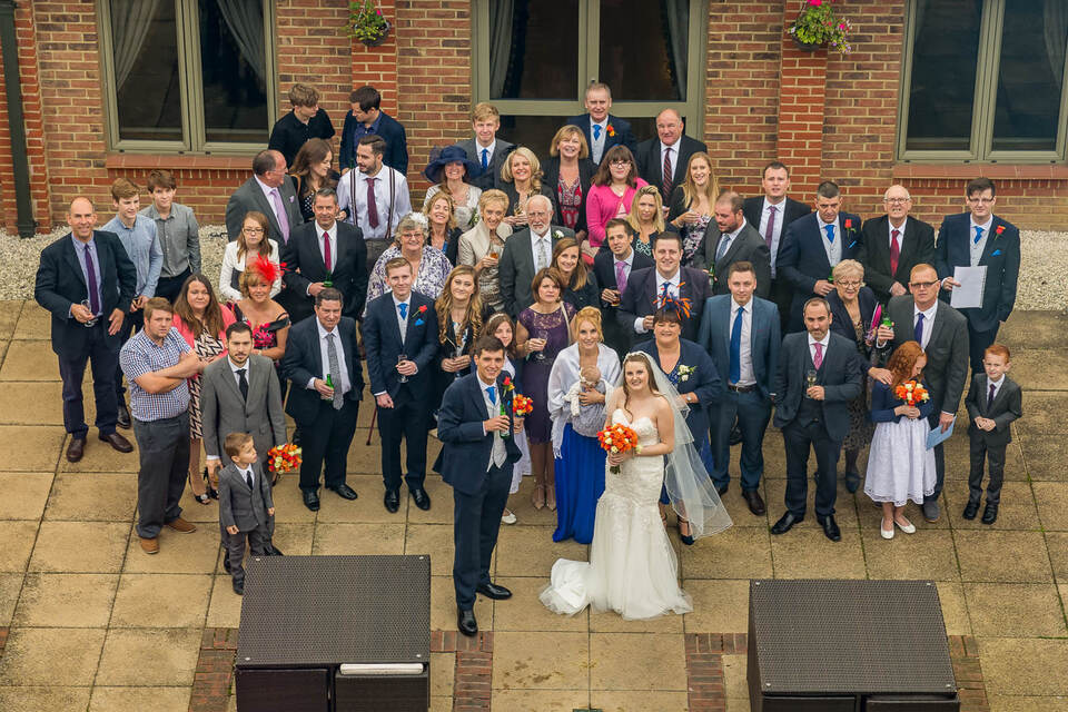 Large wedding group photo outside a brick building