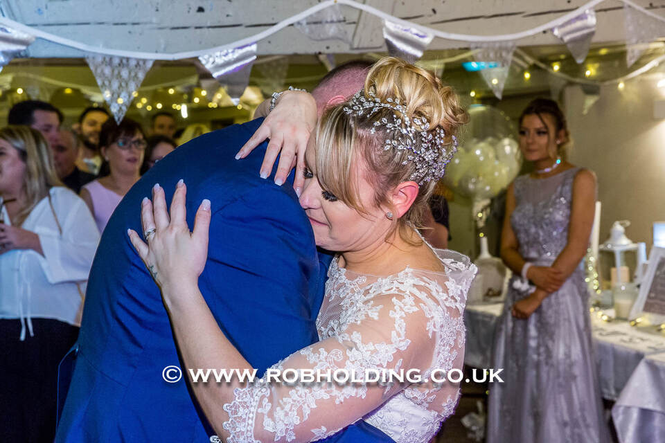 Bride and groom embracing closely indoors